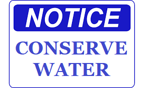 Notice with blue writing saying "Conserve Water"