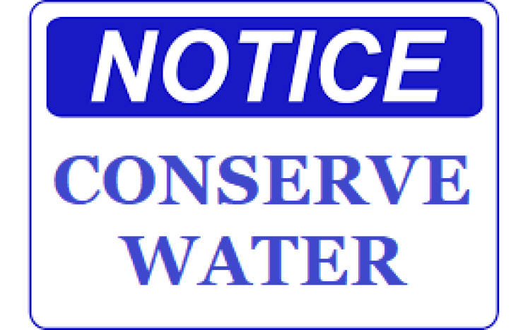 Notice with blue writing saying "Conserve Water"
